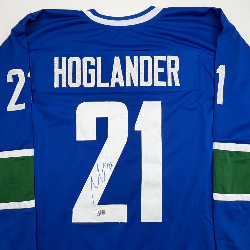 Autographed/Signed Nils Hoglander Vancouver Blue Hockey Jersey Beckett BAS COA (ONLINE ORDER ONLY)